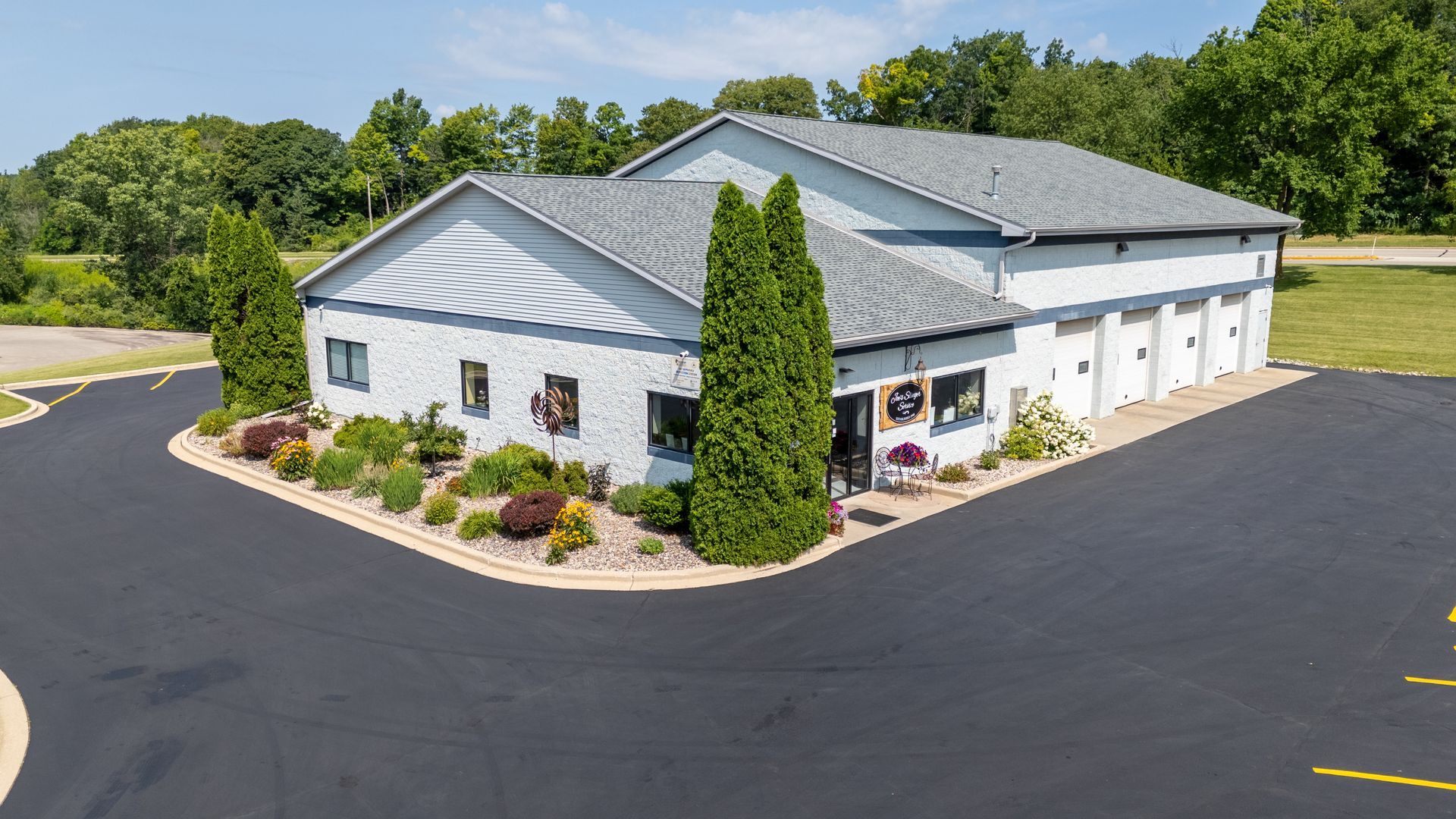 Man and woman hold giant scissors in front of a business, 