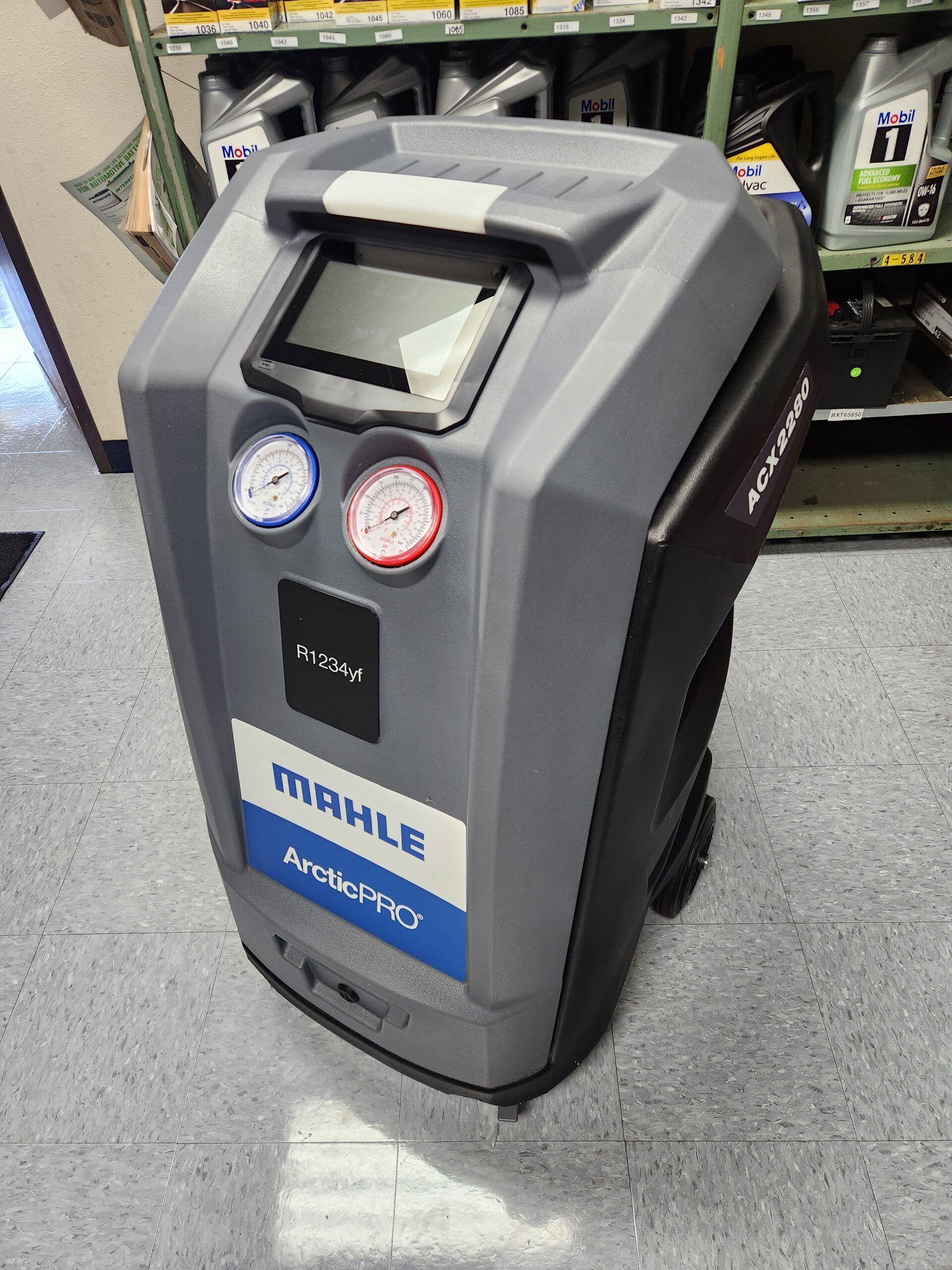A grey and black Mahle ArcticPRO AC recovery machine with gauges and a screen in a shop. | Joe's Slinger Service