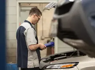 Mechanic using a diagnostic tool on a car in a repair shop | Joe's Slinger Service, LLC