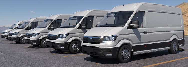 Line of gray cargo vans parked in a row, under a blue sky. | Joe's Slinger Service