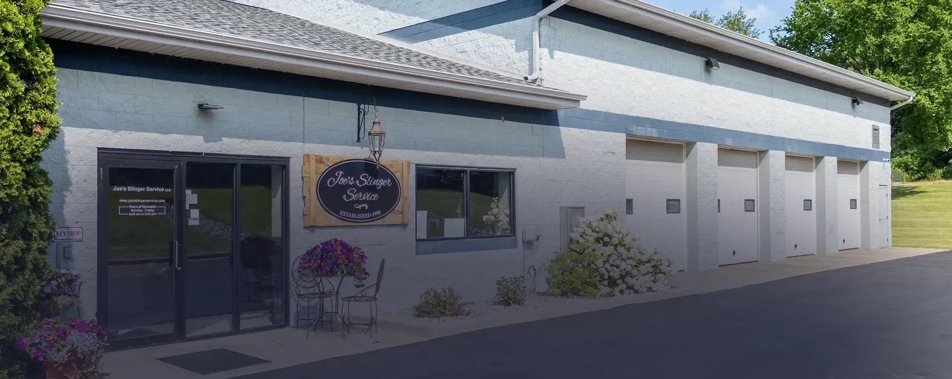 A light blue building with a cafe sign, glass doors, and garage doors.