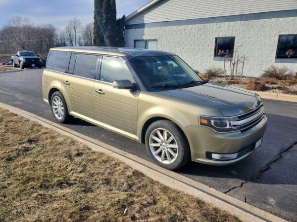 Gold Ford Flex parked on asphalt next to curb, in front of a building. | Joe's Slinger Service