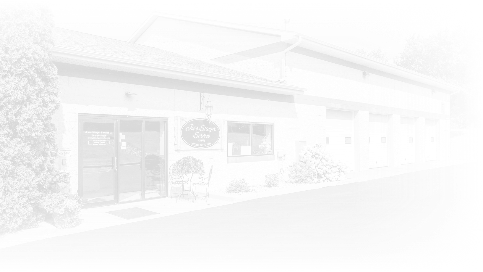Building with a storefront, partially obscured by a bright white gradient. | Joe's Slinger Service
