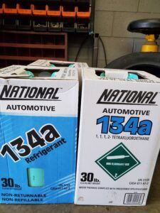 Two boxes of National Automotive 134a refrigerant. One blue, one white. | Joe's Slinger Service