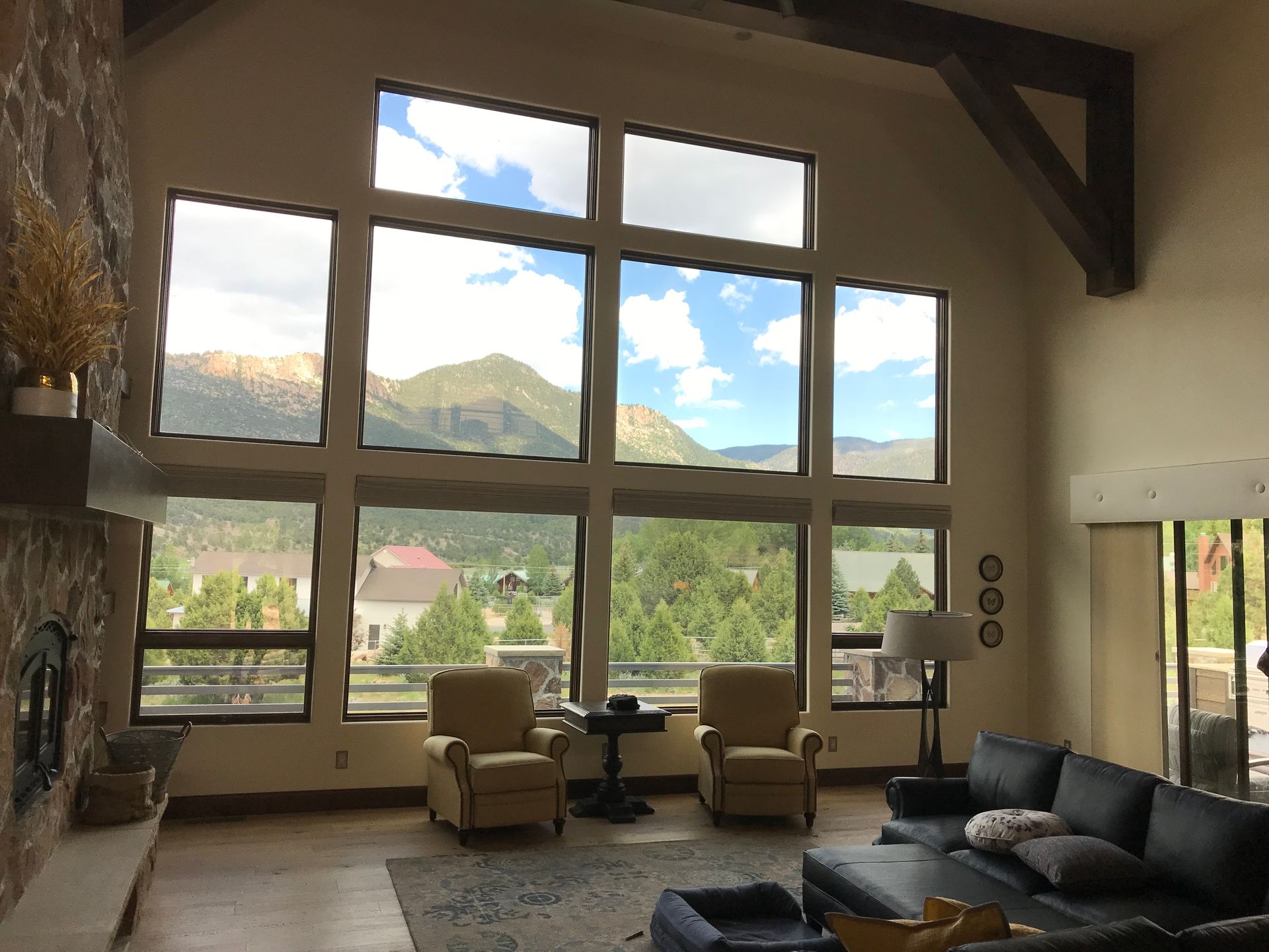 A living room with a lot of windows and mountains in the background