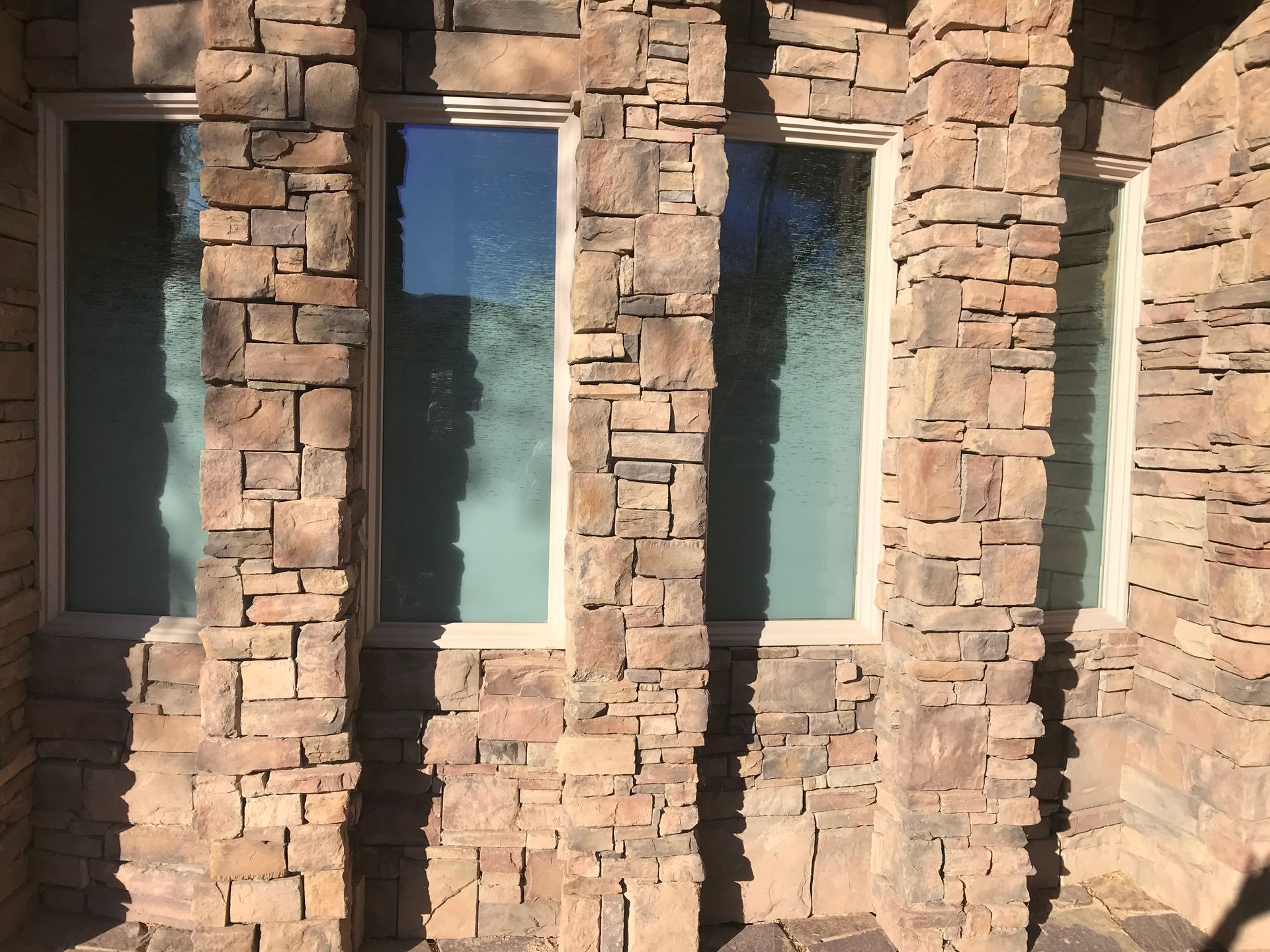 A stone wall with three windows on it