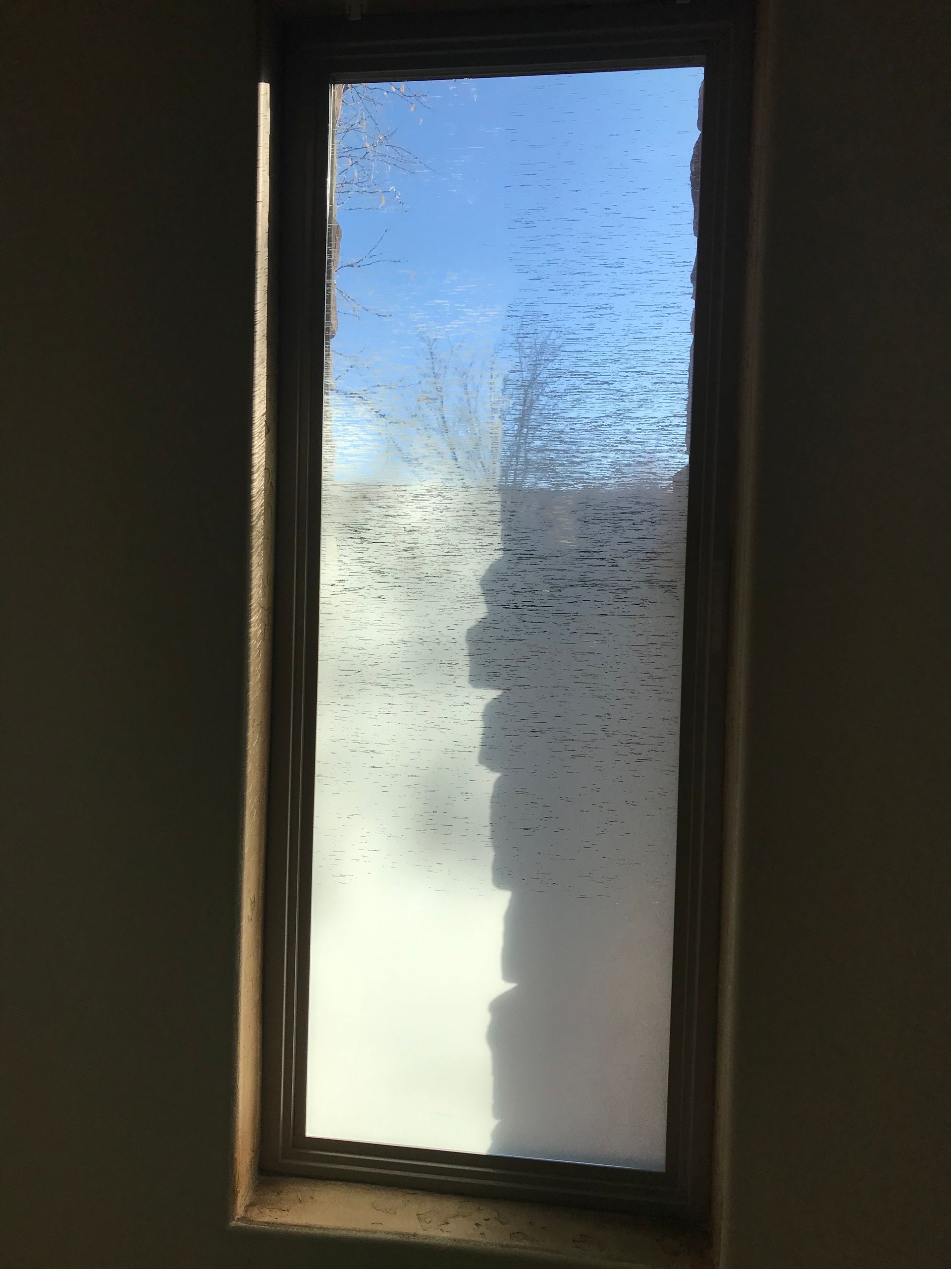 A window with a reflection of a building in it