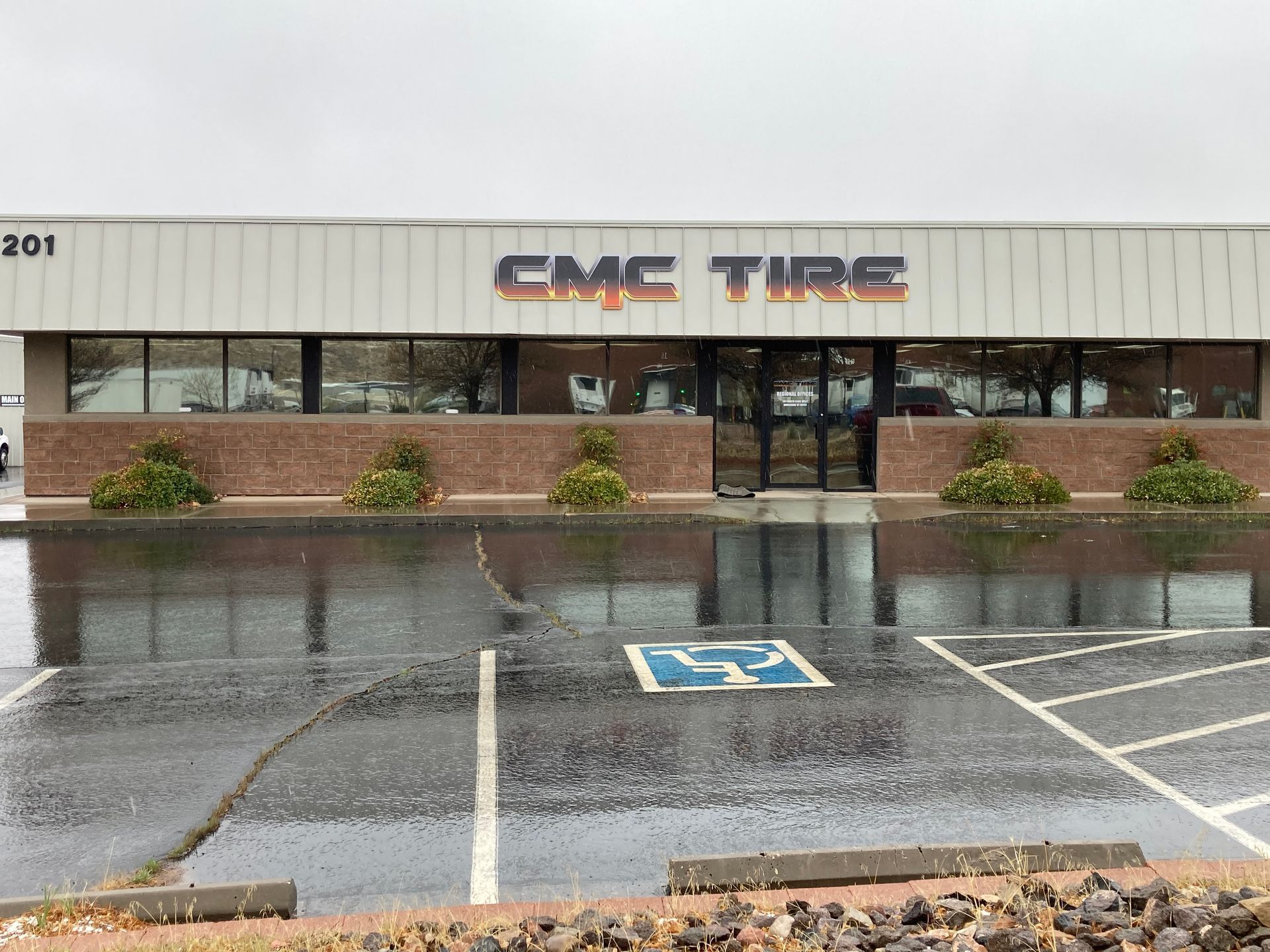 A parking lot in front of a building that says cmc tire