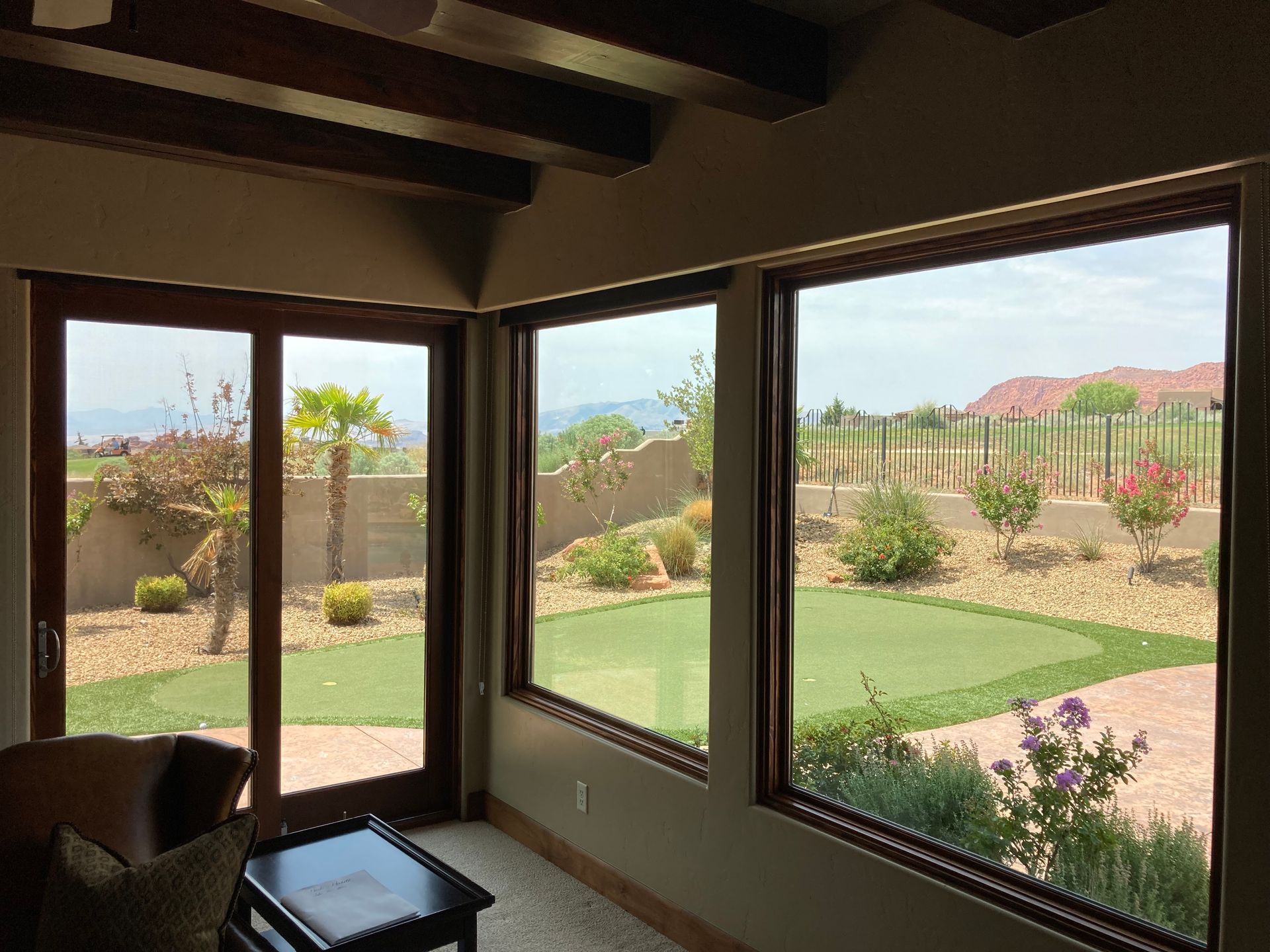 A living room with lots of windows and a view of a golf course.