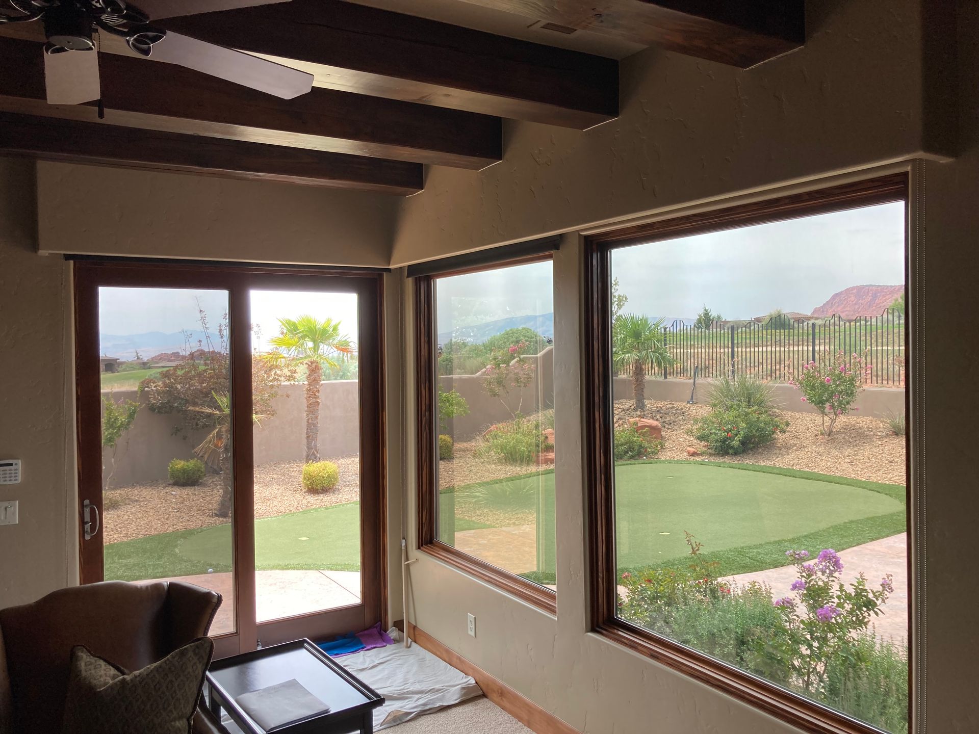 A living room with a lot of windows and a ceiling fan.