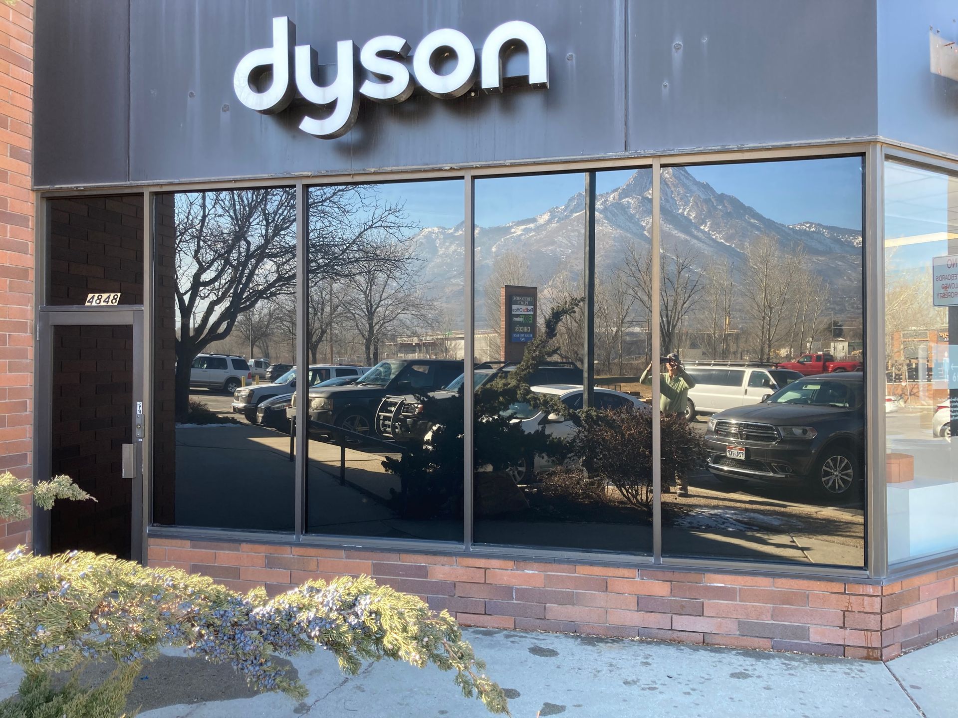 A dyson store with cars parked in front of it