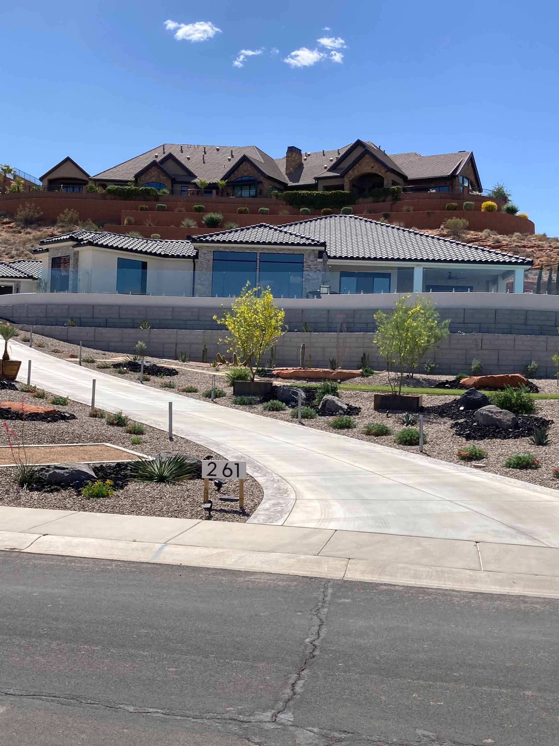 A large house sits on top of a hill next to a road