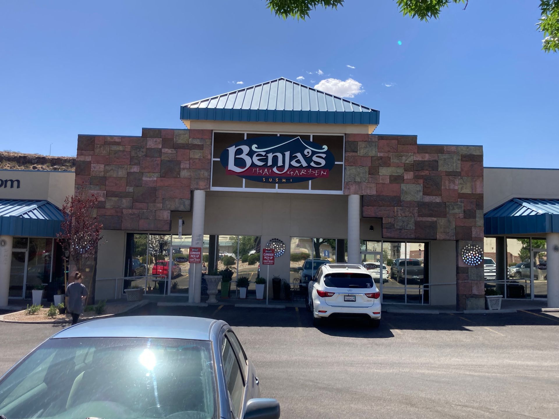 A car is parked in front of a benja 's restaurant