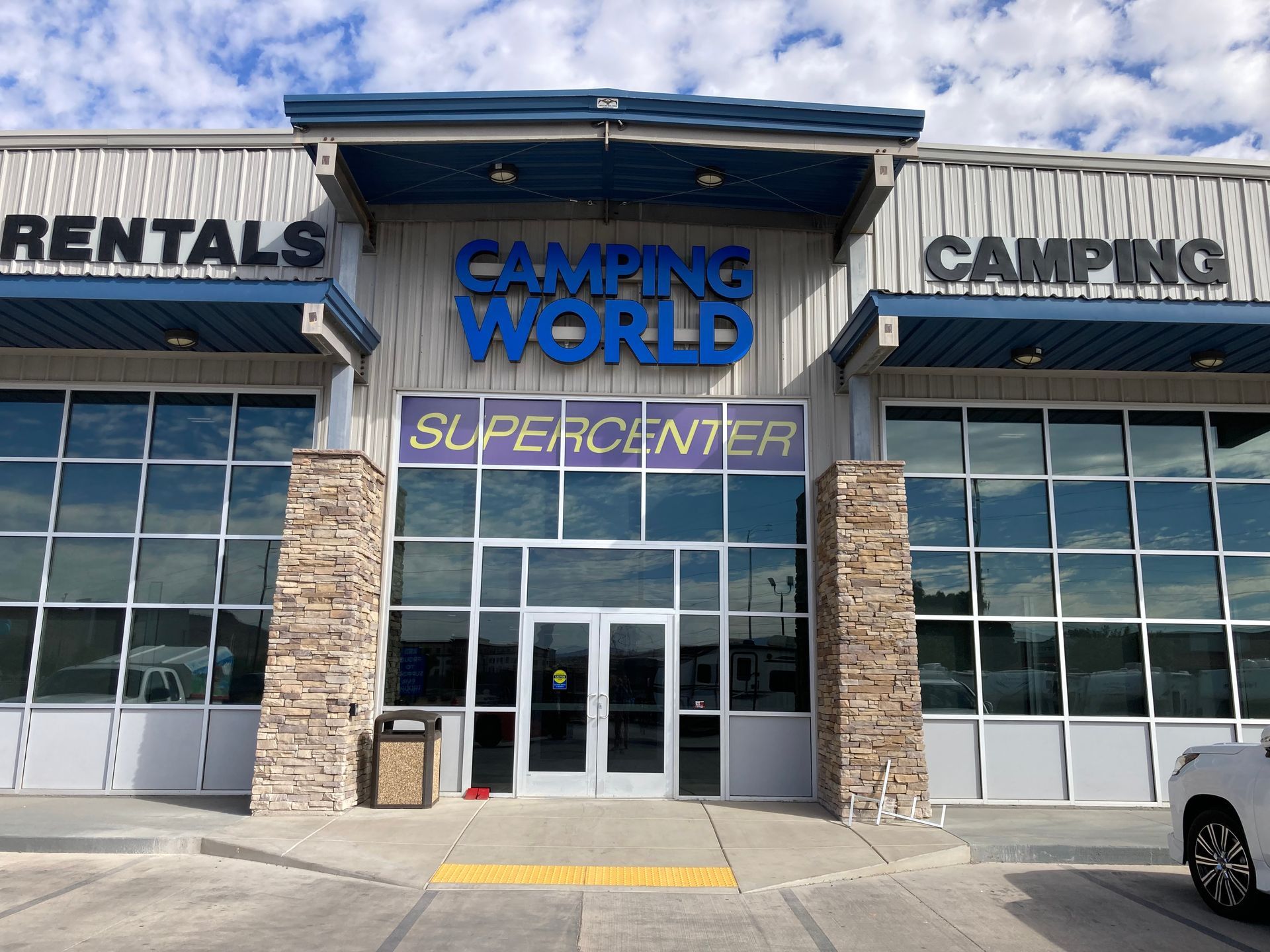 A car is parked in front of a building that says camping world supercenter