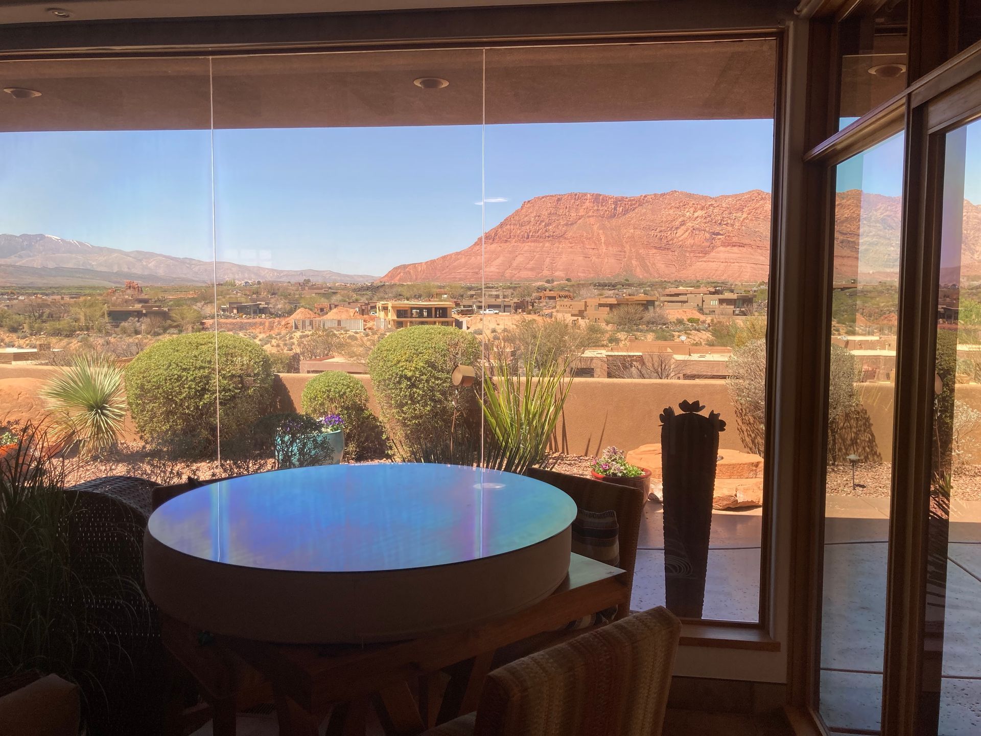 A room with a table and chairs and a view of a mountain.