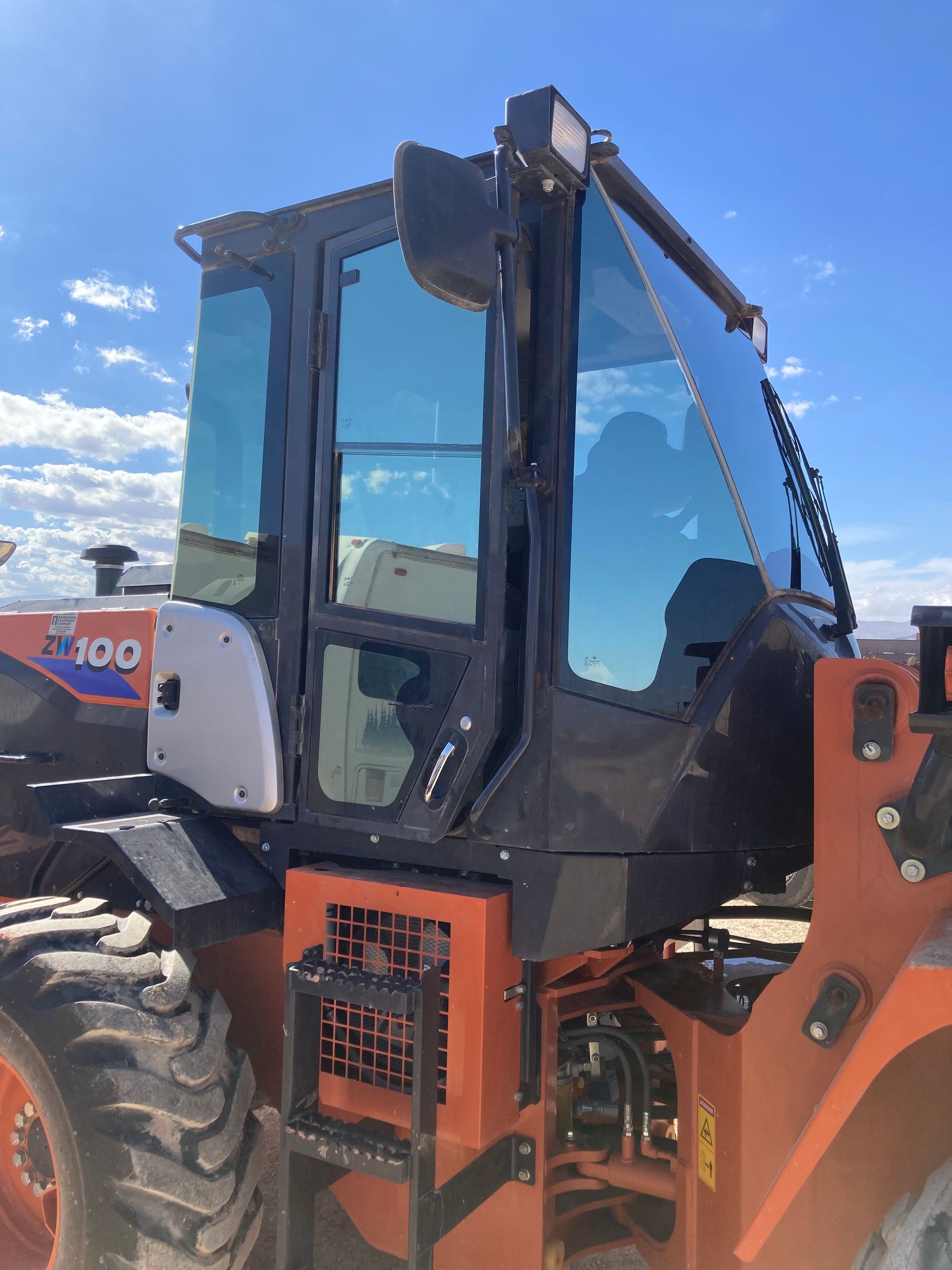 A red tractor with a blue sky in the background