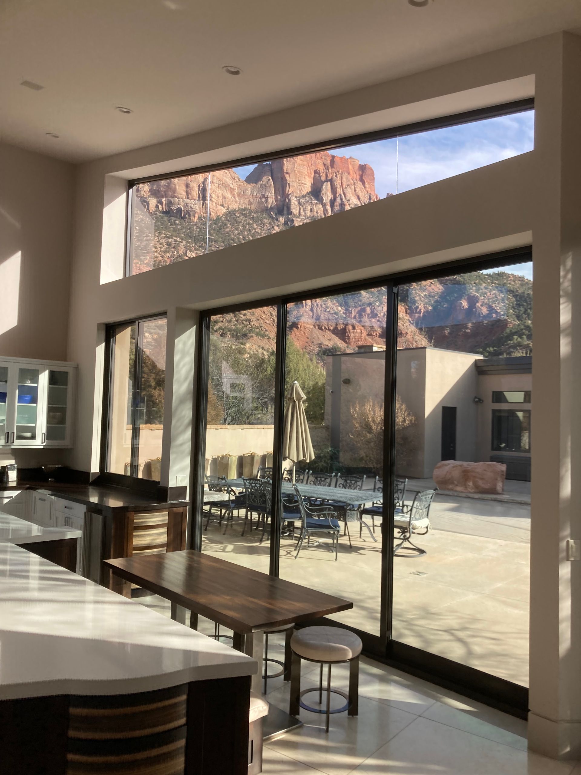 A kitchen with a table and chairs in front of a large window