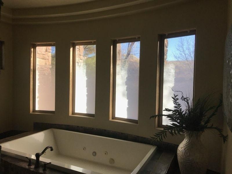 A bathroom with a jacuzzi tub and three windows