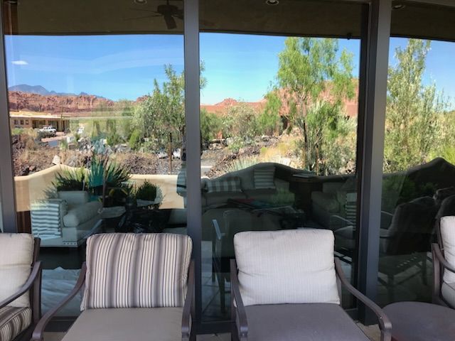 A patio with chairs and a table with a view of a mountain.