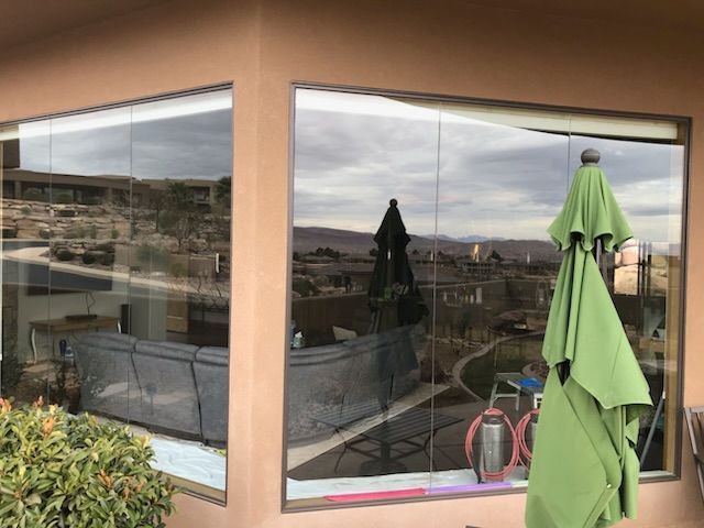 A large window with a green umbrella in front of it.
