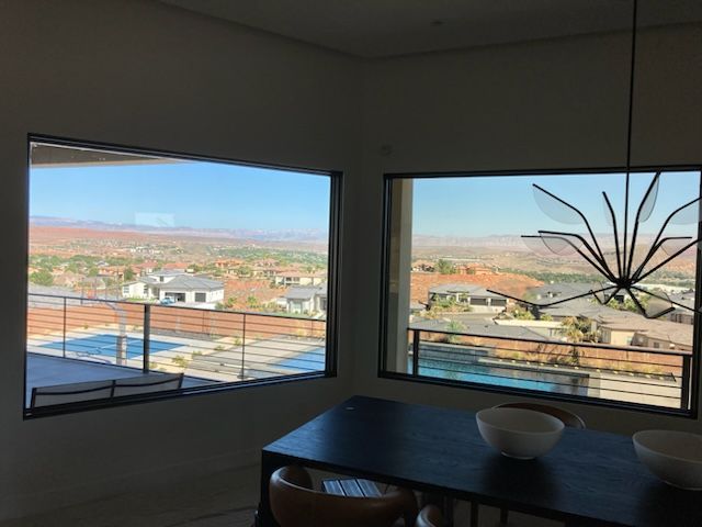 A dining room with a table and chairs and a view of a city