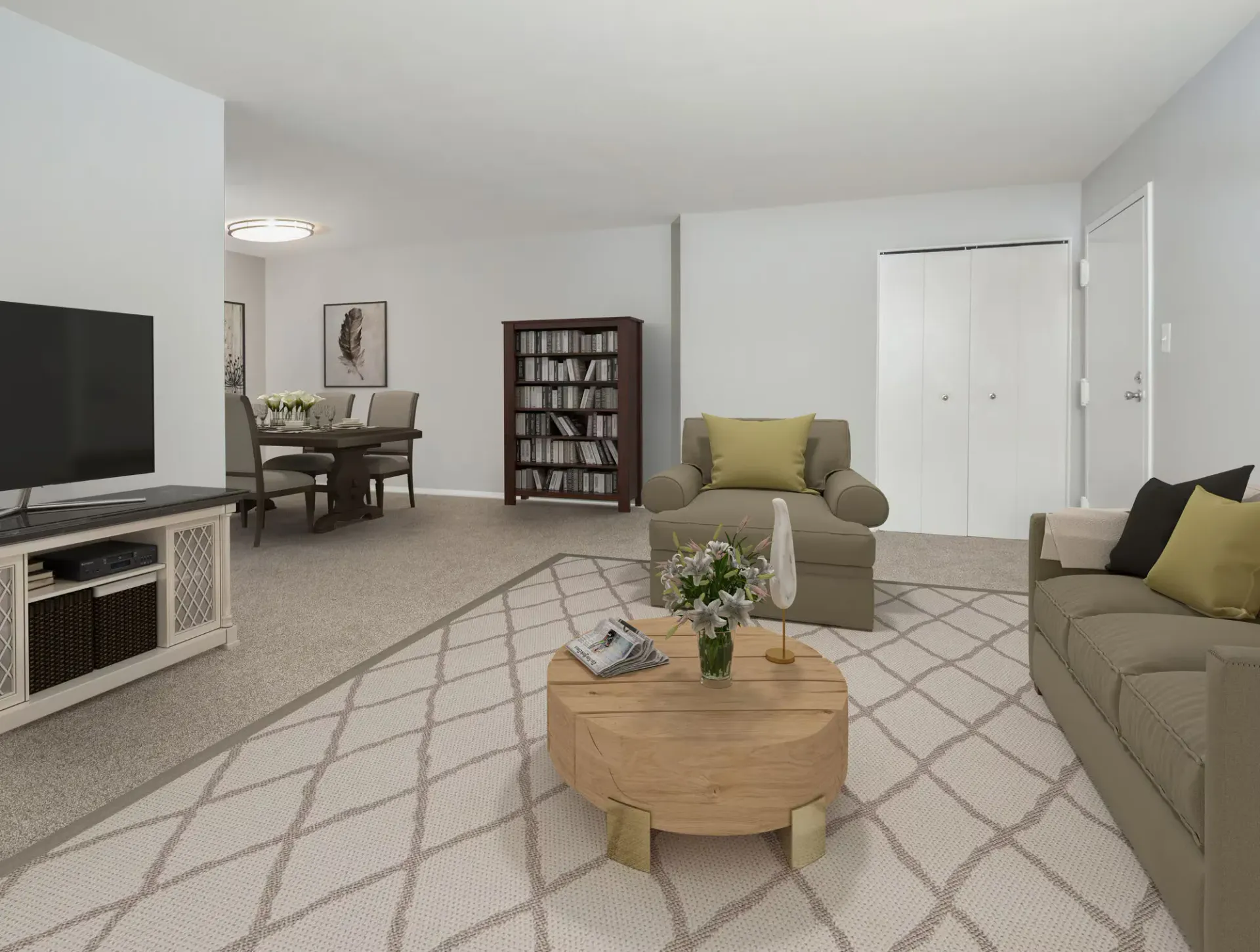 Living room with beige sofas, a coffee table, TV stand, dining table in the background, and a bookshelf.