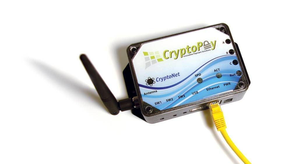 A small, silver CryptoPlay device with a black antenna and yellow Ethernet cable, set against a white background.