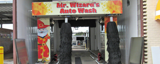 A car wash with a sign that says mr. wizard 's auto wash