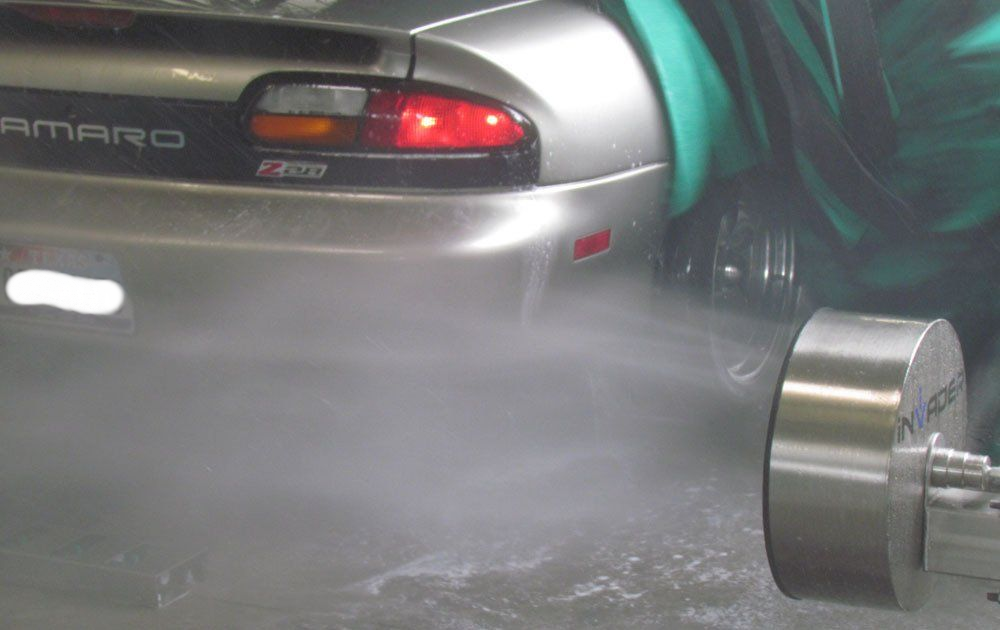 A silver car with the word camaro on the back