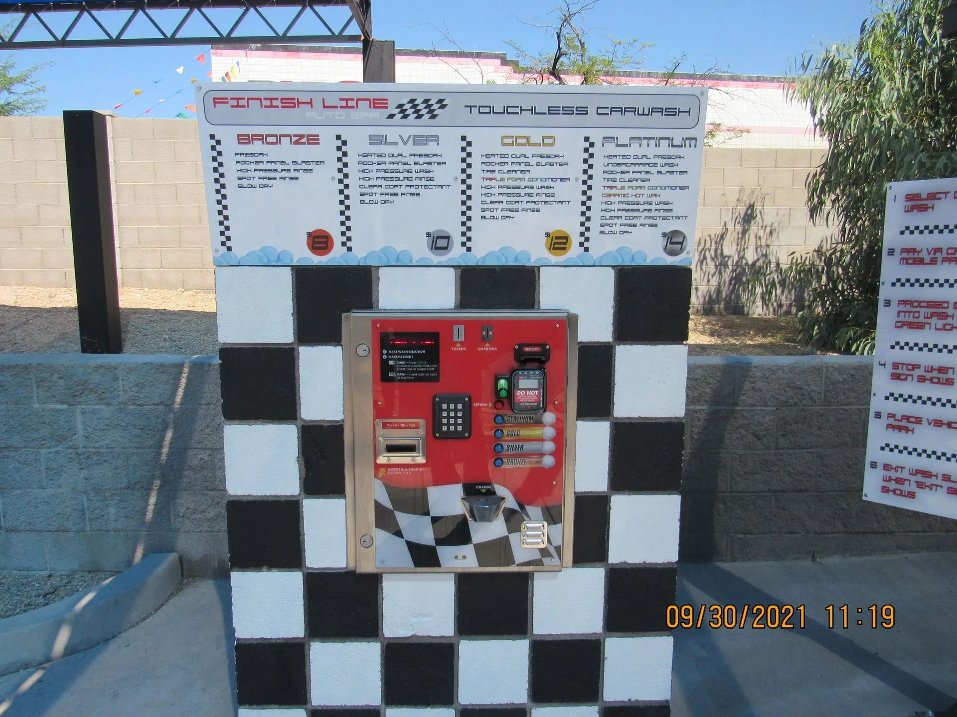 A black and white checkered wall with a red machine on it