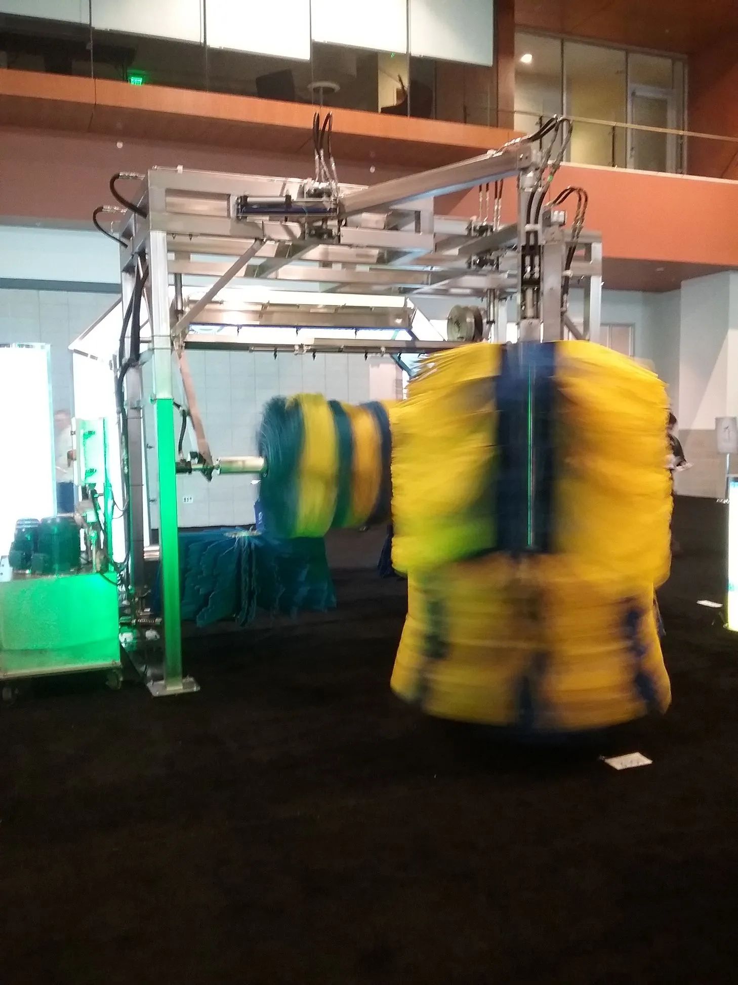 A yellow and blue machine is moving in a room