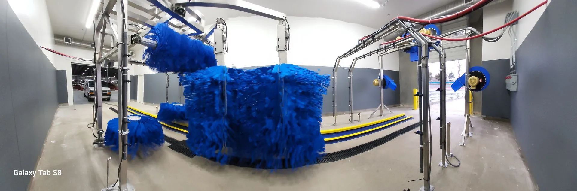 A 360 degree view of a car wash with blue brushes.