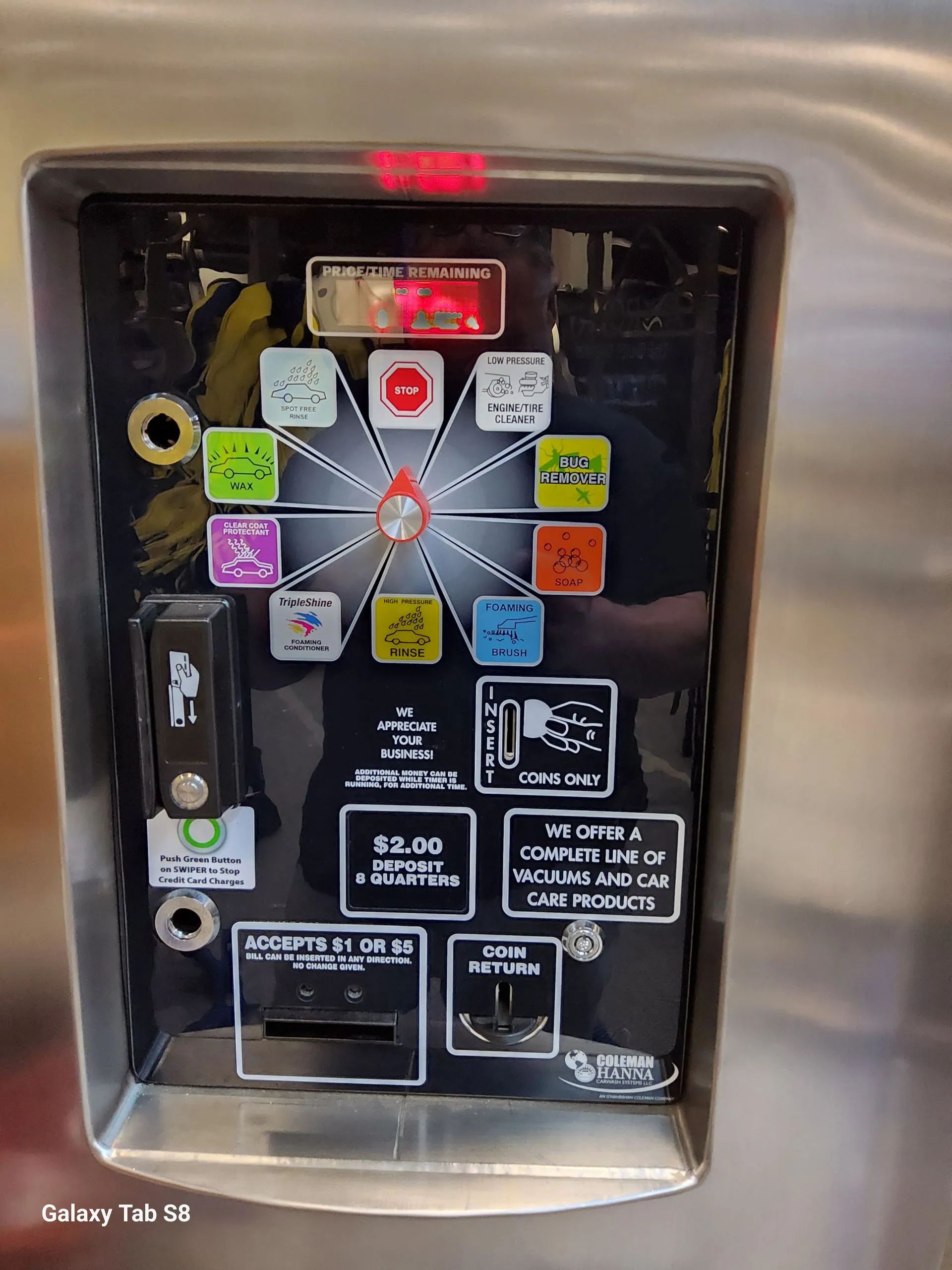 A close up of a coin machine with a lot of buttons on it