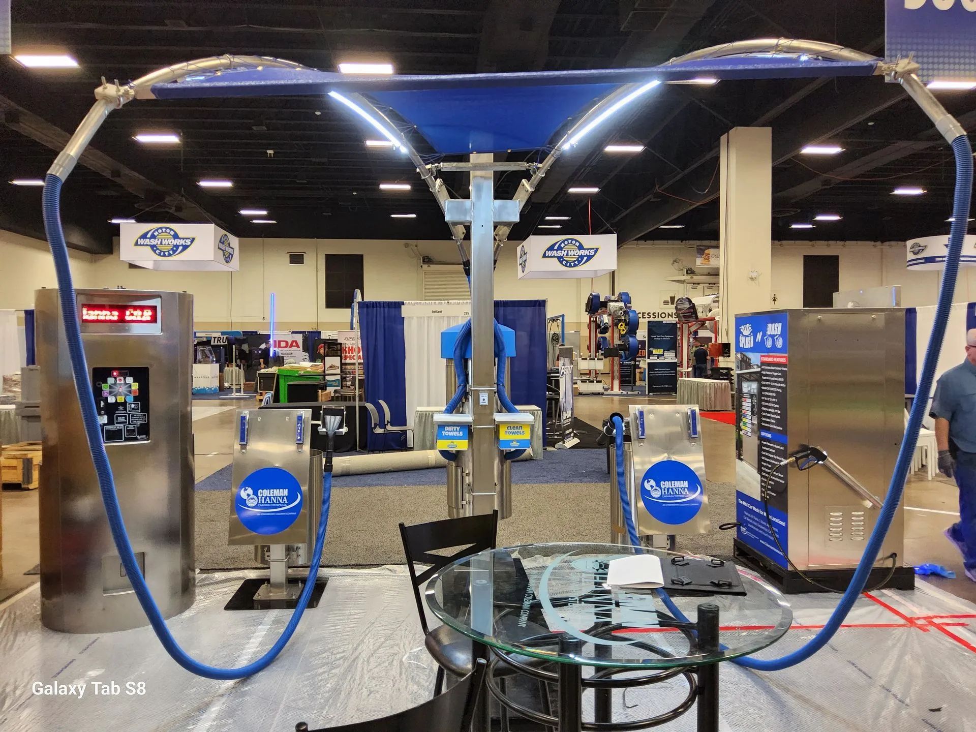 A man is standing in a room with a table and chairs.