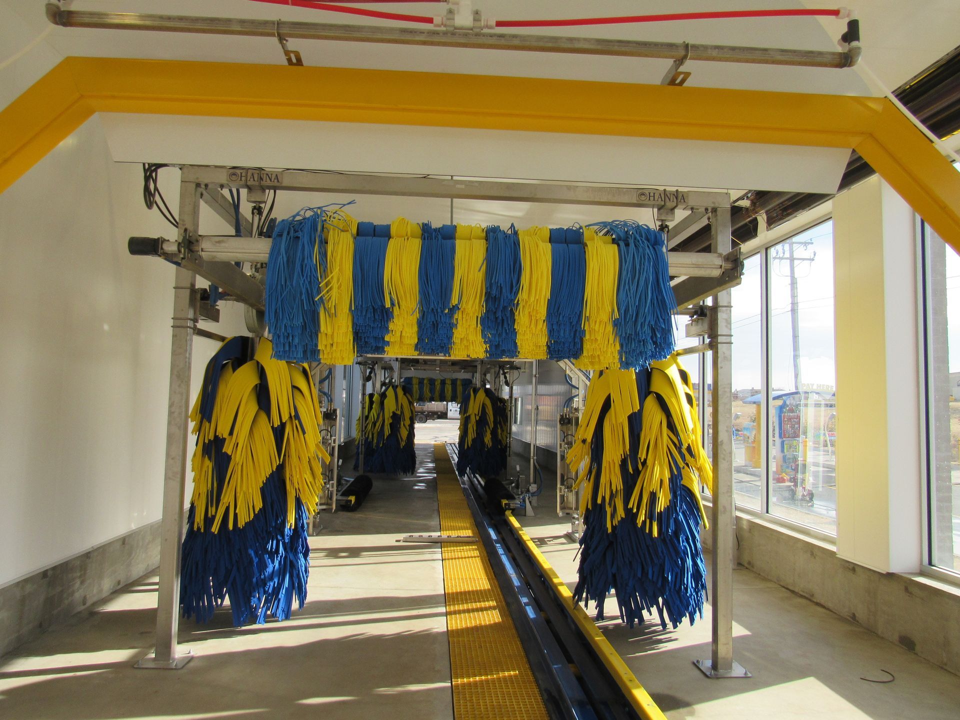 A car wash interior with blue and yellow brushes.
