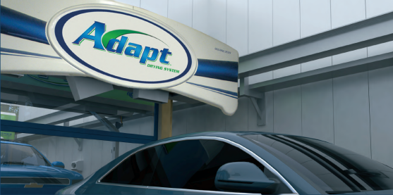 A dark car passes through a car wash marked with an