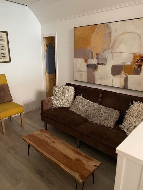 A living room with a brown couch and a wooden coffee table