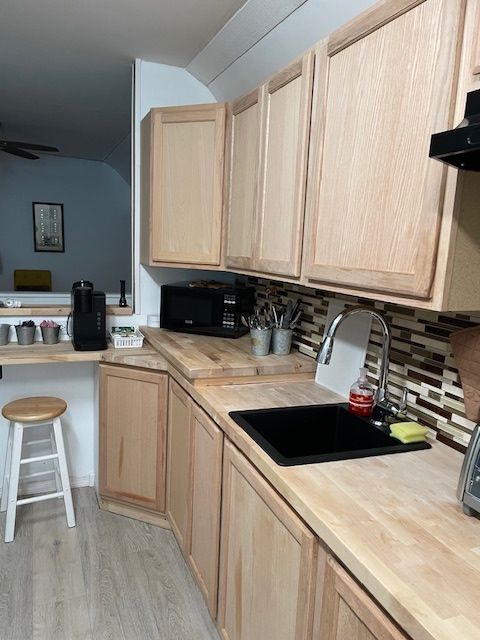 A kitchen with wooden cabinets and a sink