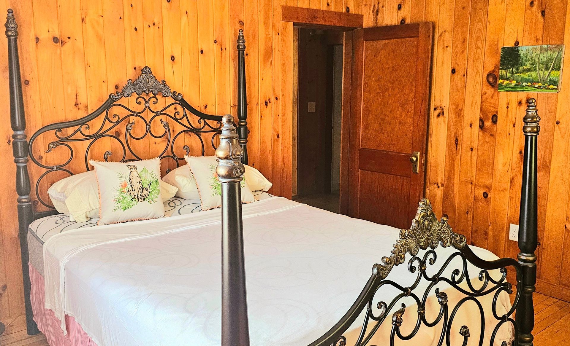 A bedroom with a bed , lamp and wooden walls.