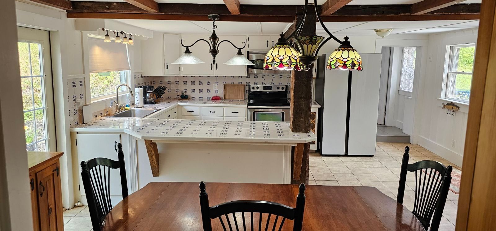 A kitchen with a table and chairs and a refrigerator.