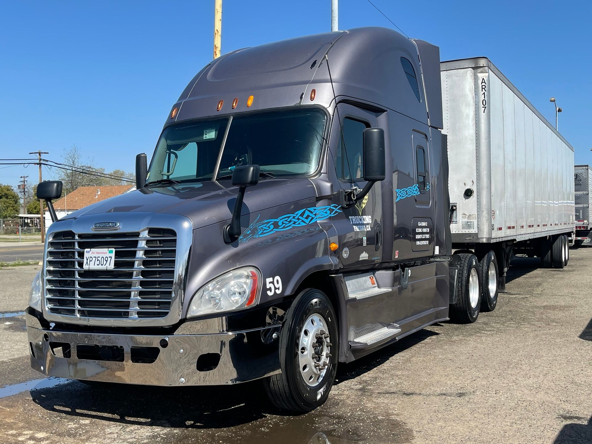 A semi truck with a trailer is parked on the side of the road.