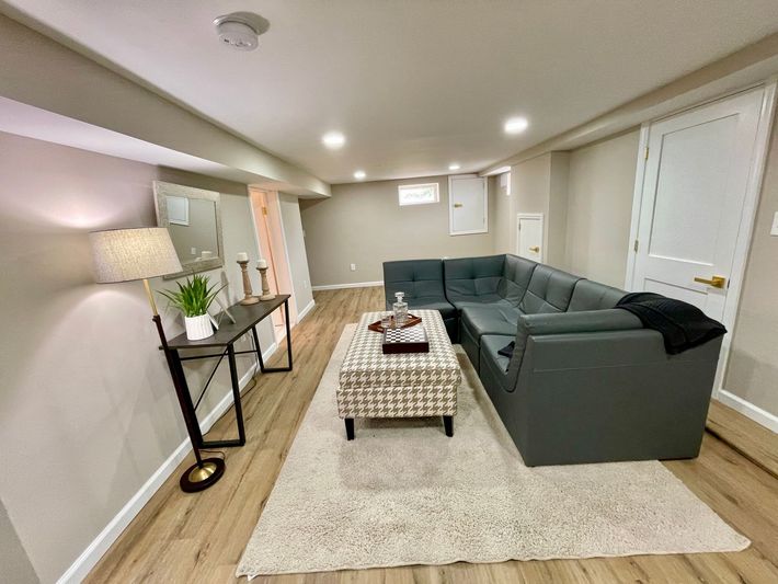 A living room in a basement with a couch and a coffee table.