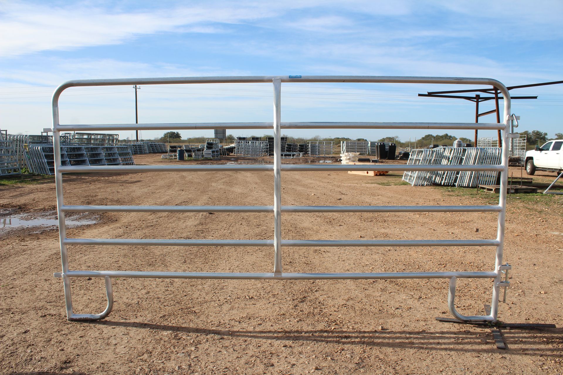 A metal gate is sitting in the middle of a dirt field