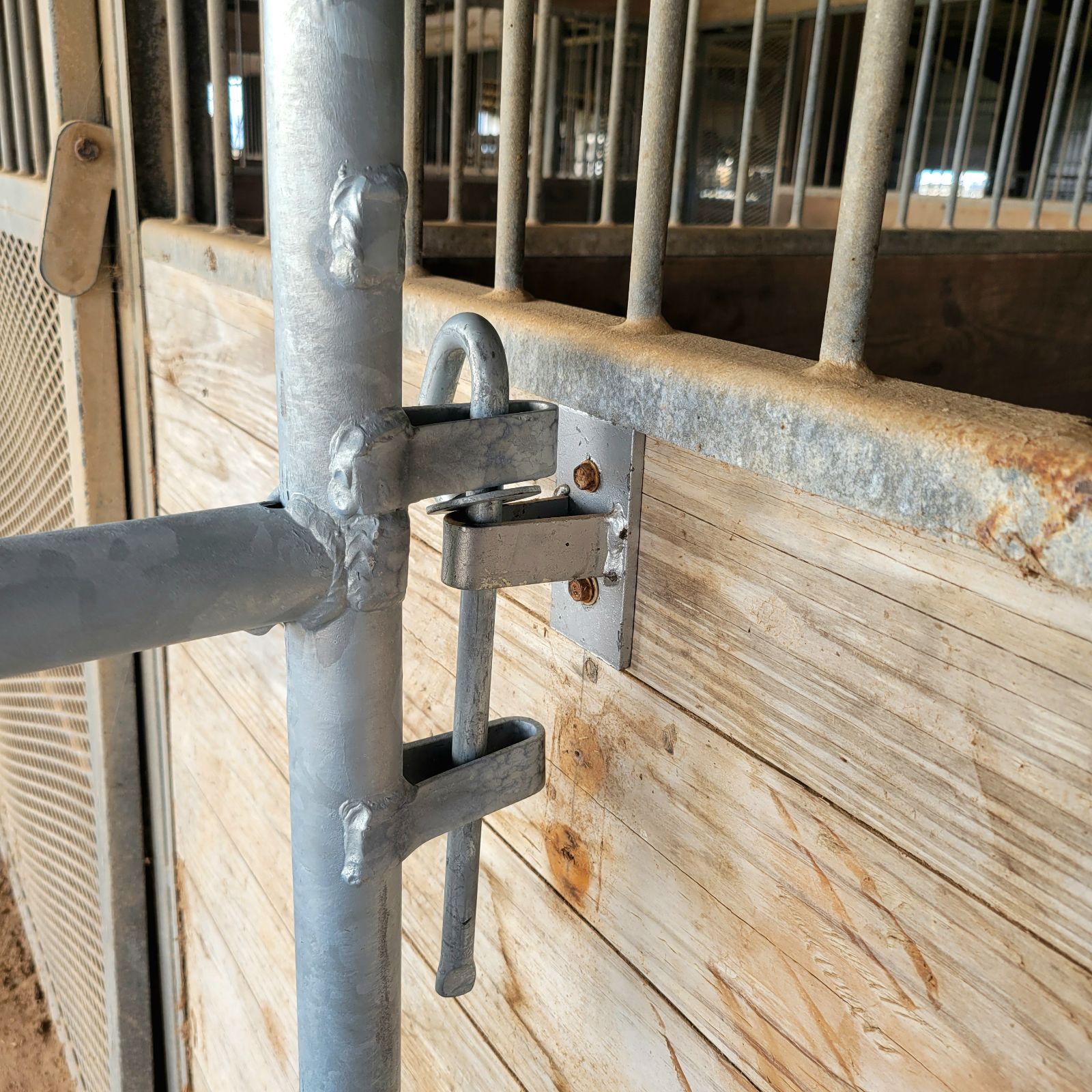 A metal pole is attached to a wooden fence