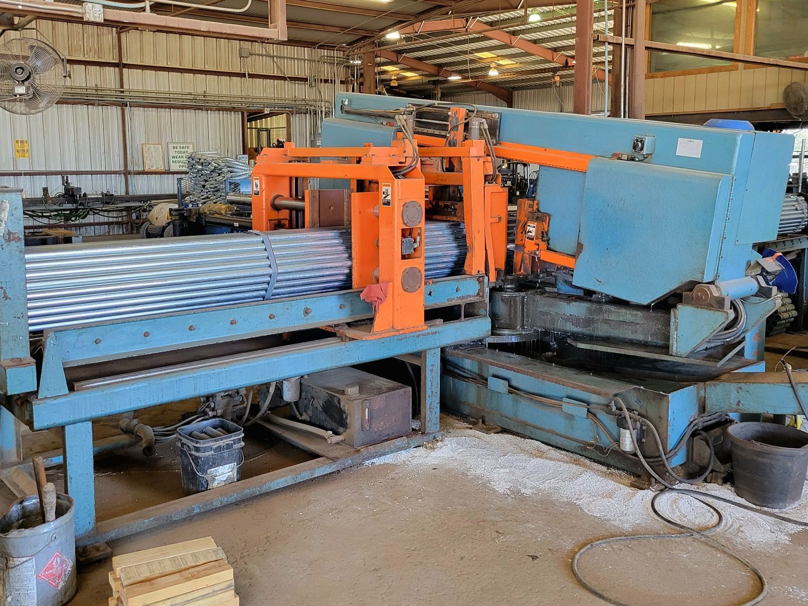 A machine is cutting a piece of metal in a warehouse.