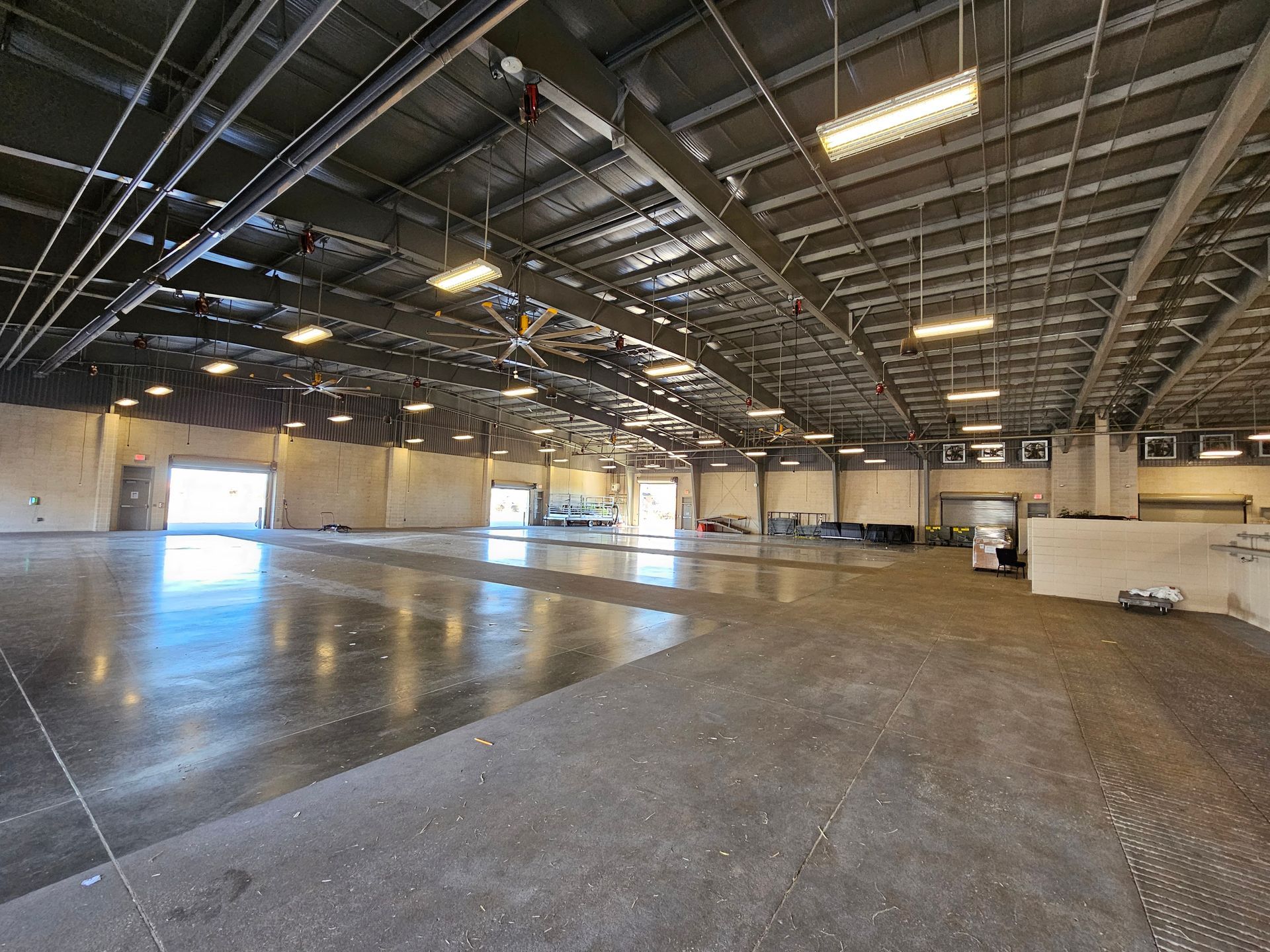 A large empty warehouse with a lot of lights on the ceiling.