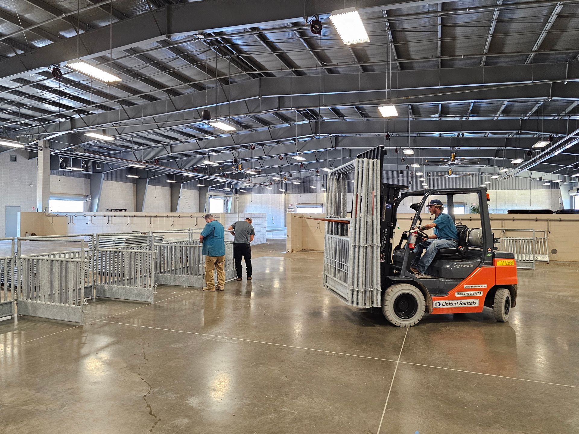 A man is driving a forklift in a large warehouse.