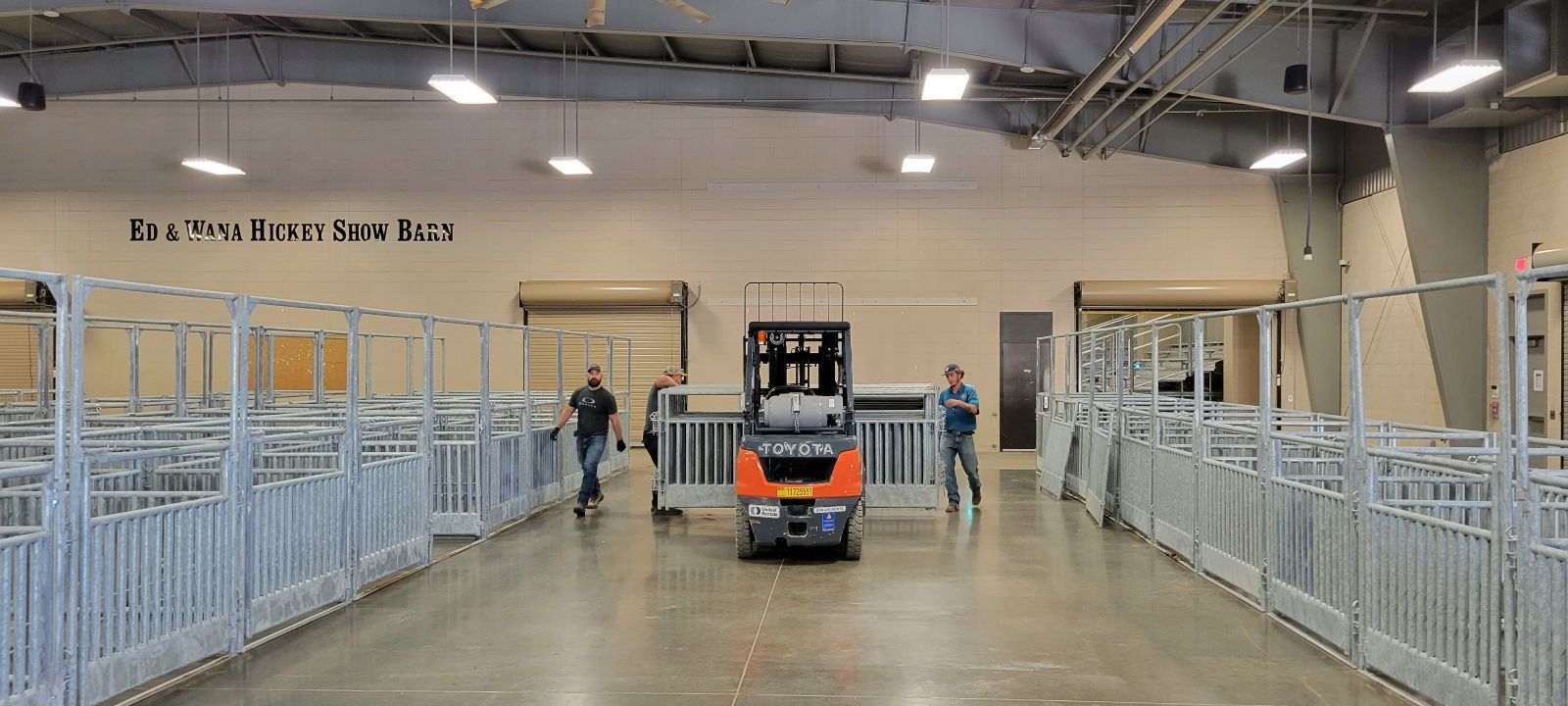 A forklift is driving down a concrete floor in a warehouse.