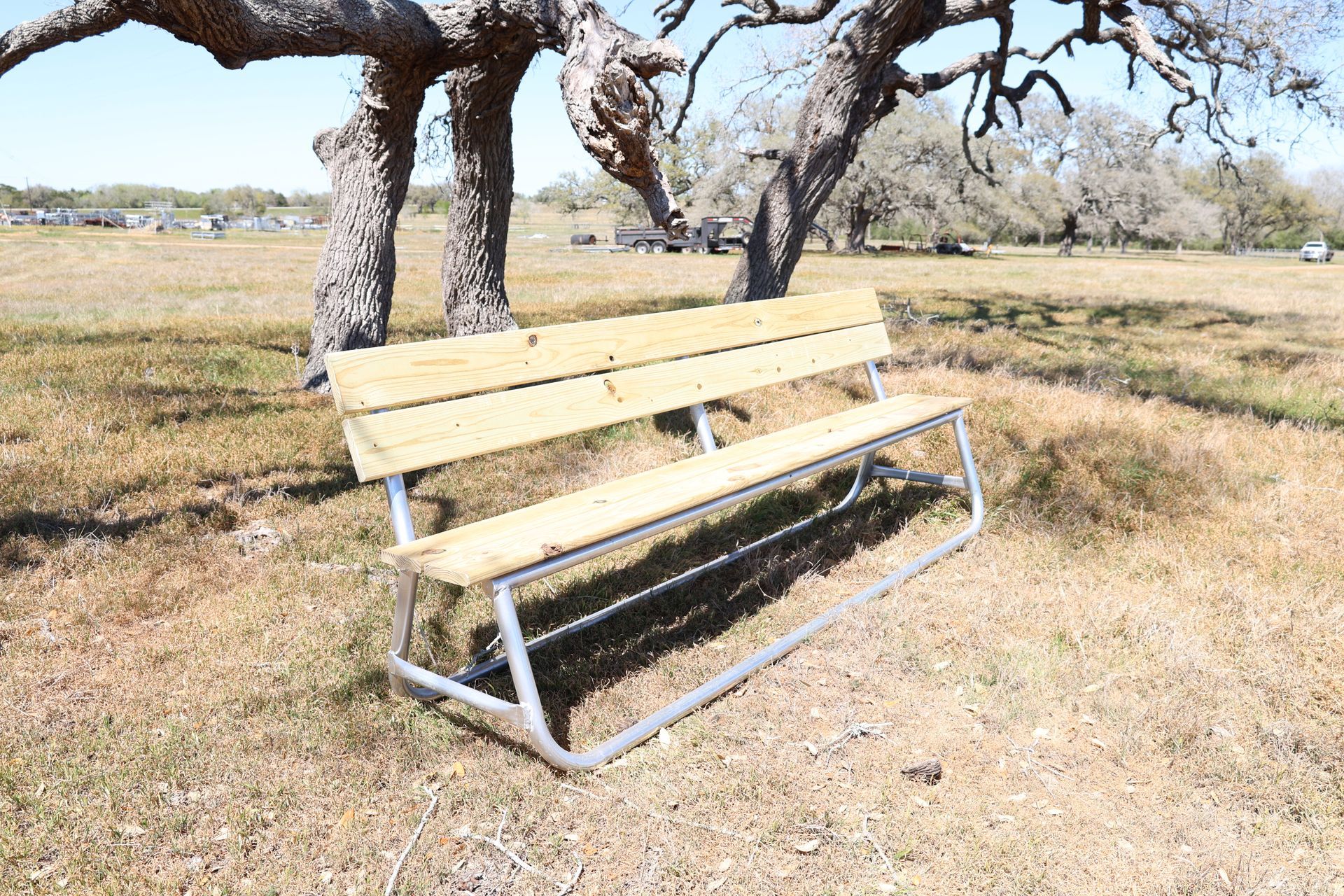 A wooden bench is sitting on a wooden deck next to a tree.