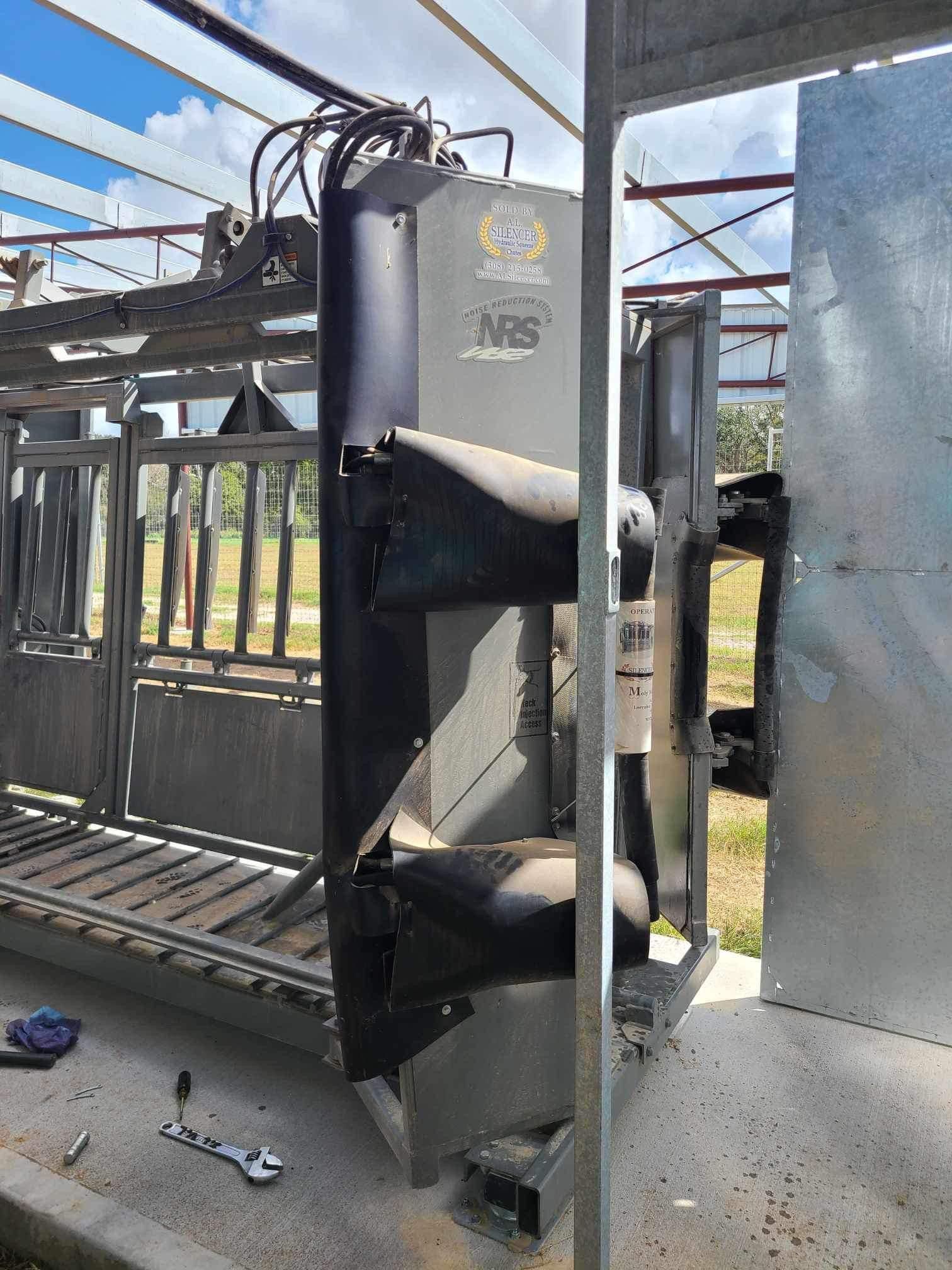 A large machine is sitting on the ground next to a fence.